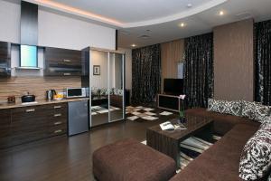 Una sala de estar con un sofá y una cocina. en Darhan Boutique Hotel, en Tashkent