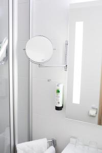 uma casa de banho branca com um lavatório e um espelho em Hotel Cap Polonio em Pinneberg
