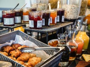 a buffet with several trays of pastries and drinks at Hôtel Inn Design & Restaurant Rochefort in Rochefort