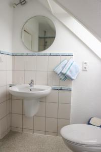 a bathroom with a sink and a toilet and a mirror at Romantischer Winkel in Neuharlingersiel