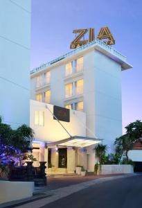 a white building with a sign in front of it at Zia Hotel Kuta in Kuta