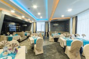 une salle de banquet avec des tables et des chaises dans un restaurant dans l'établissement Aquamarine hotel&spa, à Koursk