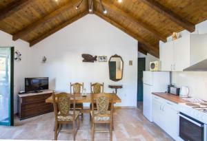 uma cozinha e sala de jantar com uma mesa de madeira e cadeiras em Holiday House Macić em Vis