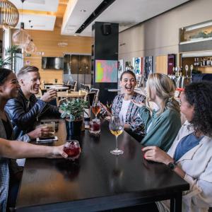a group of people sitting around a table in a restaurant at Hotel Helka in Helsinki