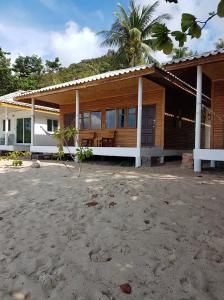 a house with a palm tree in front of it at Bottle Beach 2 Bungalows in Bottle Beach