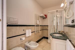a bathroom with a sink and a toilet and a shower at Apollo Apartments Colosseo in Rome
