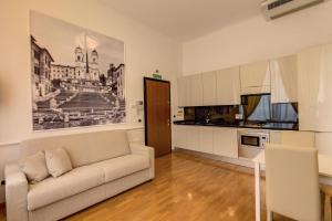 a living room with a couch and a kitchen at Apollo Apartments Colosseo in Rome