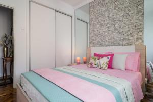 a bedroom with a pink and blue bed with two candles at Dream City Home in Caldas da Rainha