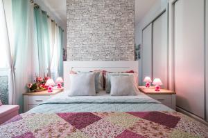 カルダス・ダ・ライーニャにあるDream City Homeのベッドルーム1室(大型ベッド1台、ランプ付きテーブル2台付)