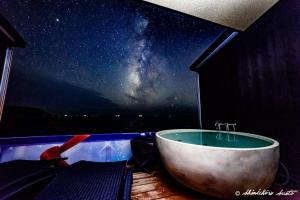 a bath tub in a room with a view of the universe at XYZ Private Spa and Seaside Resort in Shirahama