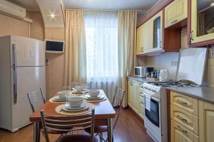 モスクワにあるLux-Apartments улица Леснорядскаяのキッチン(テーブル、椅子、白い冷蔵庫付)