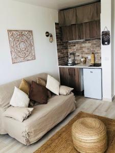a living room with a couch and a kitchen at Beauté d un jour in Empuriabrava