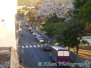 a busy city street with cars and a bus at La Plaine Verte Guesthouse in Port Louis