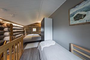 ルカにあるUnelmaKöngäsのログキャビン内のベッドルーム1室(ベッド2台付)