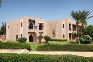 un gran edificio con árboles y arbustos delante de él en Marrakech Ryads Parc All inclusive, en Marrakech