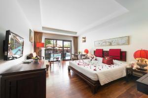 Khaolak Oriental Resort - Adult Only في خاو لاك: غرفة نوم مع سرير وغرفة معيشة