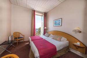 pokój hotelowy z dużym łóżkiem i oknem w obiekcie Hôtel Vacances Bleues Balmoral w Mentonie