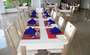 a long white table with blue napkins and napkins at Lavenro Garden in Avissawella