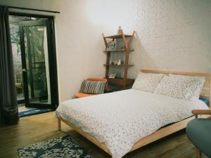 um quarto com uma cama, uma cadeira e uma janela em XiaoBei Home2 em Tainan