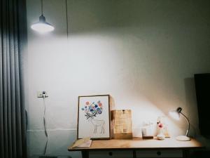 a room with a table with a lamp and a picture at XiaoBei Home2 in Tainan