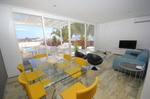 een woonkamer met gele stoelen en een blauwe bank bij Villa Maria by Villalia in Playa Blanca