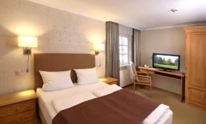 ヴィンターベルクにあるLandhaus Silberbergのベッドとテレビが備わるホテルルームです。