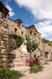 um edifício de pedra com escadas e flores em frente em La ferme des Cévennes em Florac