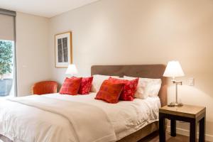 ein Schlafzimmer mit einem großen Bett mit roten Kissen in der Unterkunft Constellation Apartments in Margaret River Town