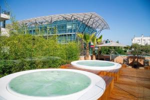 2 bañeras de hidromasaje en una terraza frente a un edificio en Metropol Ceccarini Suite - Luxury apartments, en Riccione
