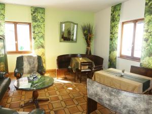 - un salon avec une table, des chaises et un miroir dans l'établissement Hôtel Restaurant Aux Deux Roses, à Neuf-Brisach
