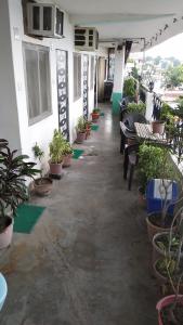 a patio with potted plants and tables and benches at Ganga Paying Guest House in Varanasi