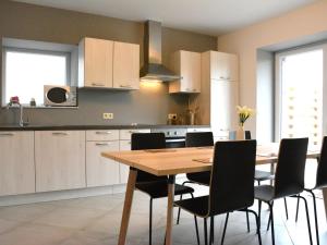 uma cozinha com uma mesa de madeira e cadeiras em Vintage Holiday Home in Couvin near River em Aublain