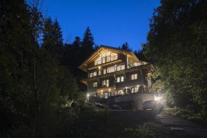 duży drewniany dom w nocy z oświetleniem w obiekcie Schweizerhaus w mieście Alpirsbach