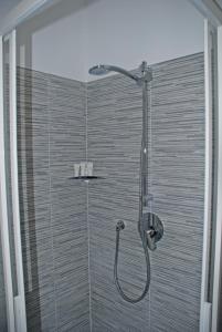 La salle de bains est pourvue d'une douche avec un pommeau de douche. dans l'établissement Bonne Nuit Guest House, à Azzano San Paolo