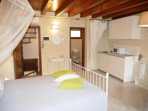 a bedroom with a white bed with yellow pillows at Appartamenti Ca' nei Vicoli in Limone sul Garda