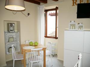Appartamenti Ca' nei Vicoli في ليموني سول غاردا: مطبخ مع طاولة وكراسي وغرفة طعام