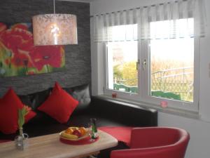 シュテルンベルクにあるClassy Holiday Home in Sternberg with Jettyのリビングルーム(テーブル、赤い椅子付)