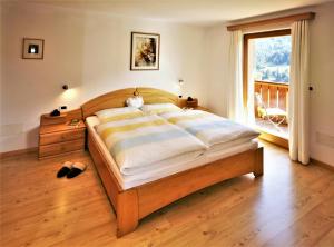 a bedroom with a large bed and a large window at Apartment Larjëi in Ortisei