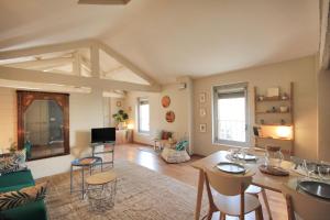 un grand salon avec une table et des chaises dans l'établissement Loft Isis - Appartement Avignon centre, à Avignon