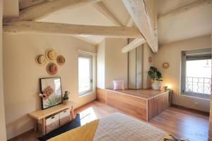 Cette grande chambre est dotée de parquet et de fenêtres. dans l'établissement Loft Isis - Appartement Avignon centre, à Avignon