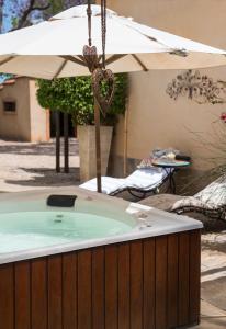 a jacuzzi tub with an umbrella in a yard at Casa Mia Health Spa and Guesthouse in Addo