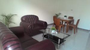 een woonkamer met een leren bank en een tafel bij Balige J&J Guest House 2 in Balige