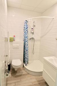 Un baño blanco con ducha y WC. en Mindaugo 1A, en Vilna