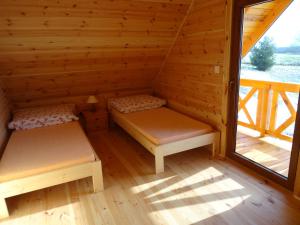 セイニにあるDereniowe Wzgórzeのログキャビン内のベッド2台が備わる部屋です。