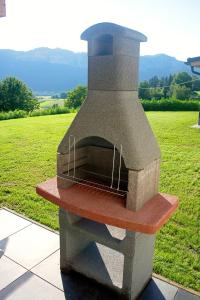 un forno a legna in pietra per la pizza, seduto in cima a un campo di Ferienhaus Kaiser a Gallizien