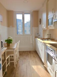 uma cozinha com uma mesa, um lavatório, uma mesa e cadeiras em Duplex soleado, Calle Corrida, Casco Antiguo em Gijón