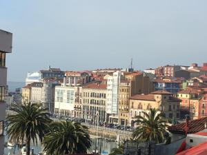 uma vista para uma cidade com palmeiras e edifícios em Duplex soleado, Calle Corrida, Casco Antiguo em Gijón