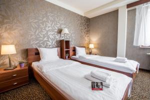 una camera d'albergo con due letti con lenzuola bianche di Hotel Diament Vacanza Katowice - Siemianowice a Siemianowice Śląskie