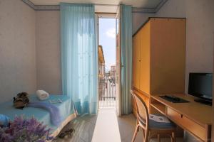 レヴァントにあるHotel Nazionaleのベッドと机と窓のある寝室