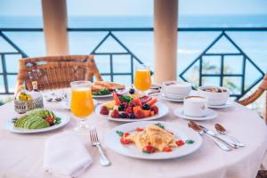 a table with plates of food and orange juice at Iberostar Grand El Mirador - Adults Only in Adeje